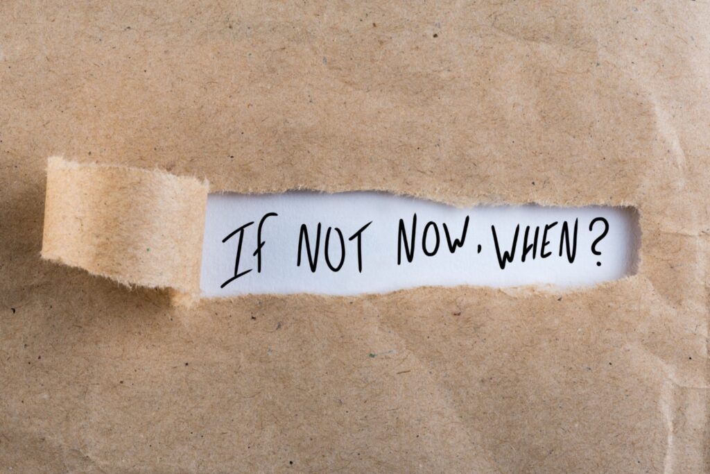Brown paper ripped back to reveal "If not now, when?" written underneath